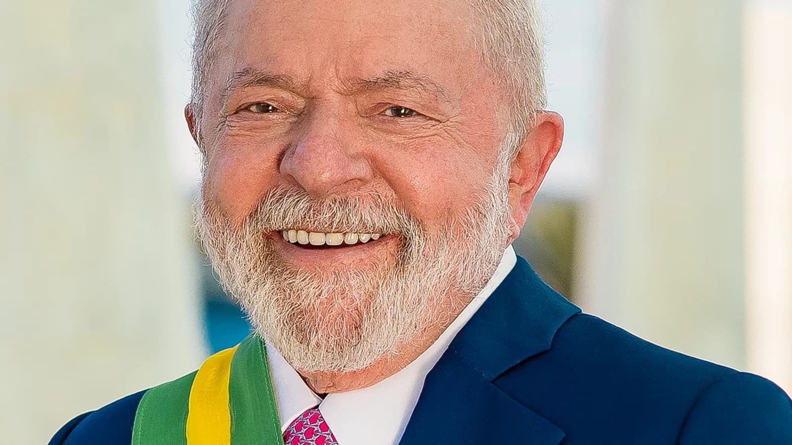 Retrato oficial do presidente Luiz Inácio Lula da Silva sorrindo, usando a faixa presidencial
