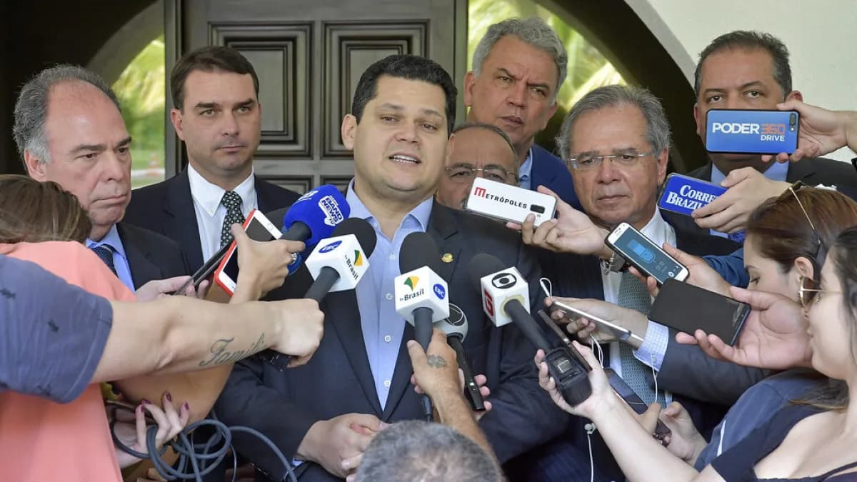Flávio Bolsonaro cercado de microfones em coletiva de imprensa