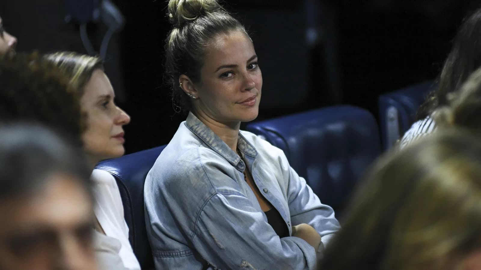Paolla Oliveira em evento no Senado, olhando para o lado, vestindo jaqueta jeans