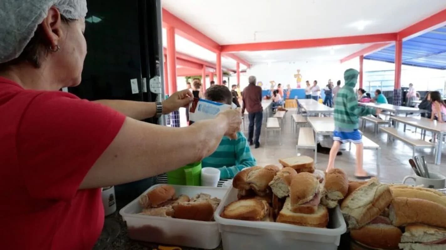 Voluntária serve sanduíches a famílias em abrigo emergencial para atingidos por chuvas no Sul do Brasil (imagem de arquivo, Joinville-SC, 2022)