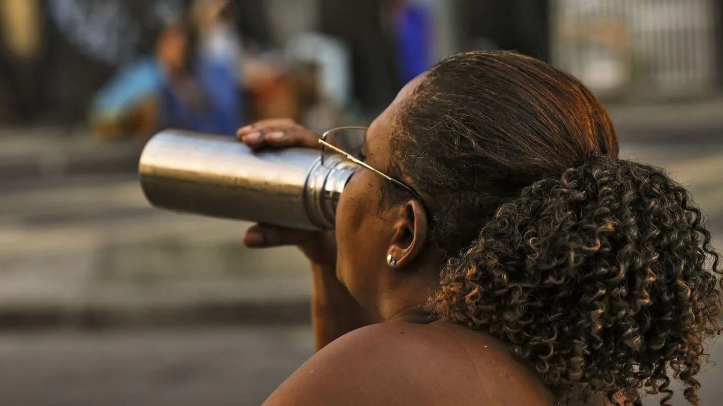 Mulher se hidrata durante onda de calor no Rio de Janeiro