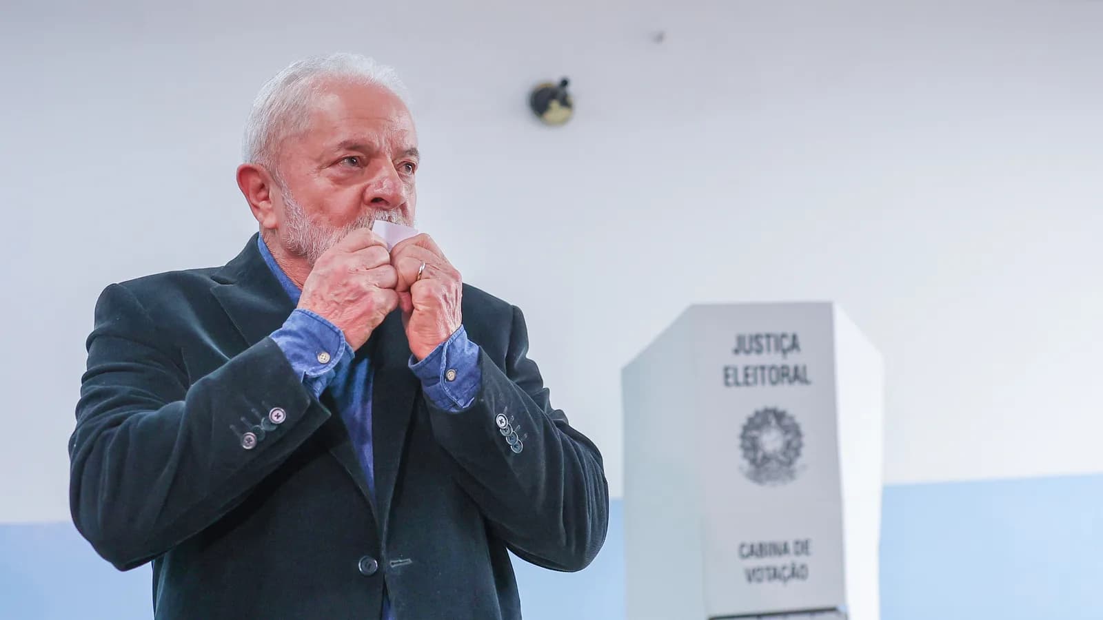 Lula beija a mão perto de cabine de votação da Justiça Eleitoral (foto de arquivo de eleição anterior em São Bernardo do Campo)