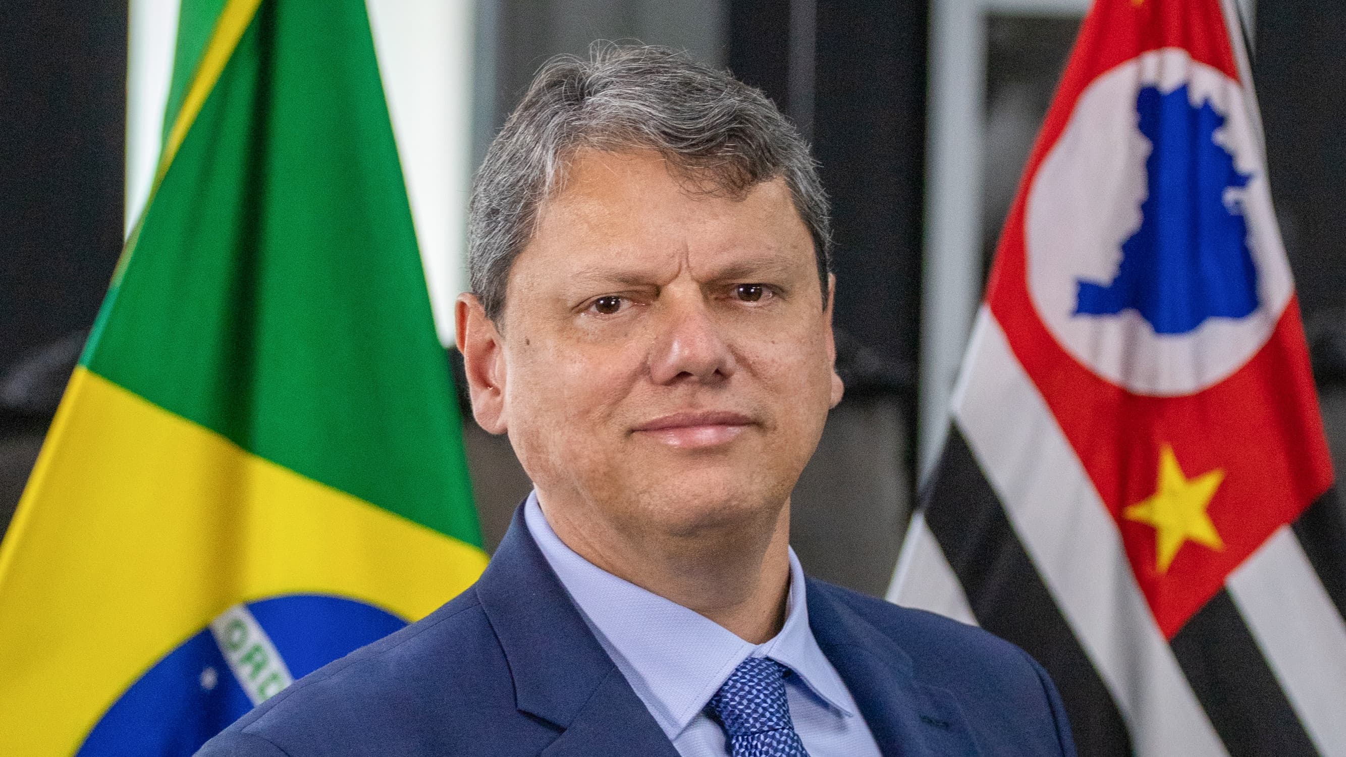 Governador Tarcísio de Freitas em retrato oficial, com bandeiras do Brasil e de São Paulo ao fundo