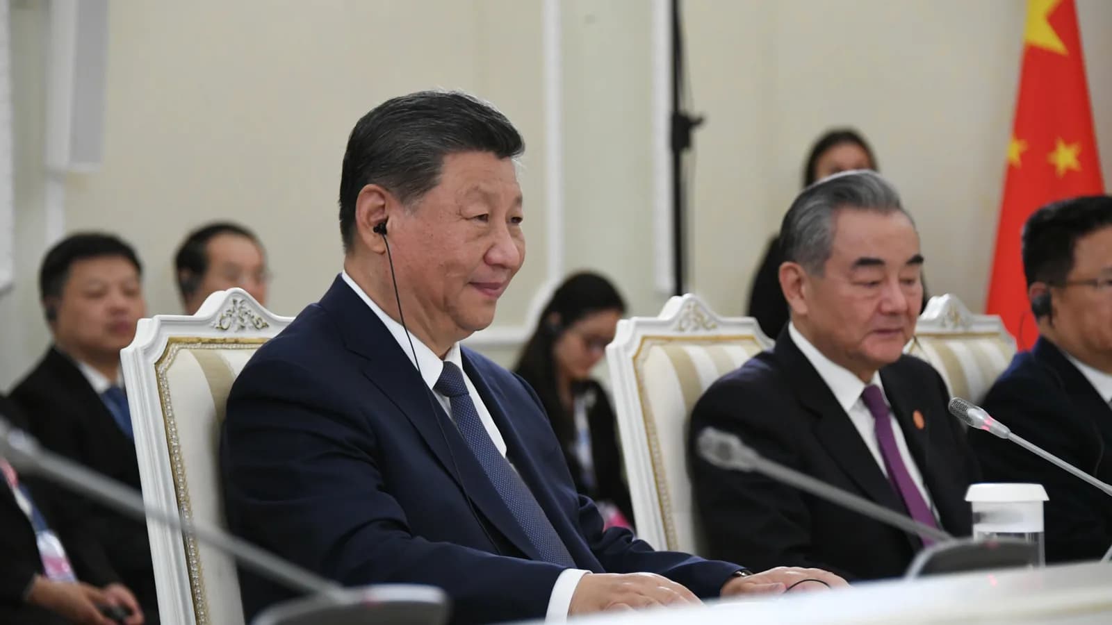 Xi Jinping em reunião de cúpula do BRICS, sentado à mesa com delegação chinesa ao fundo