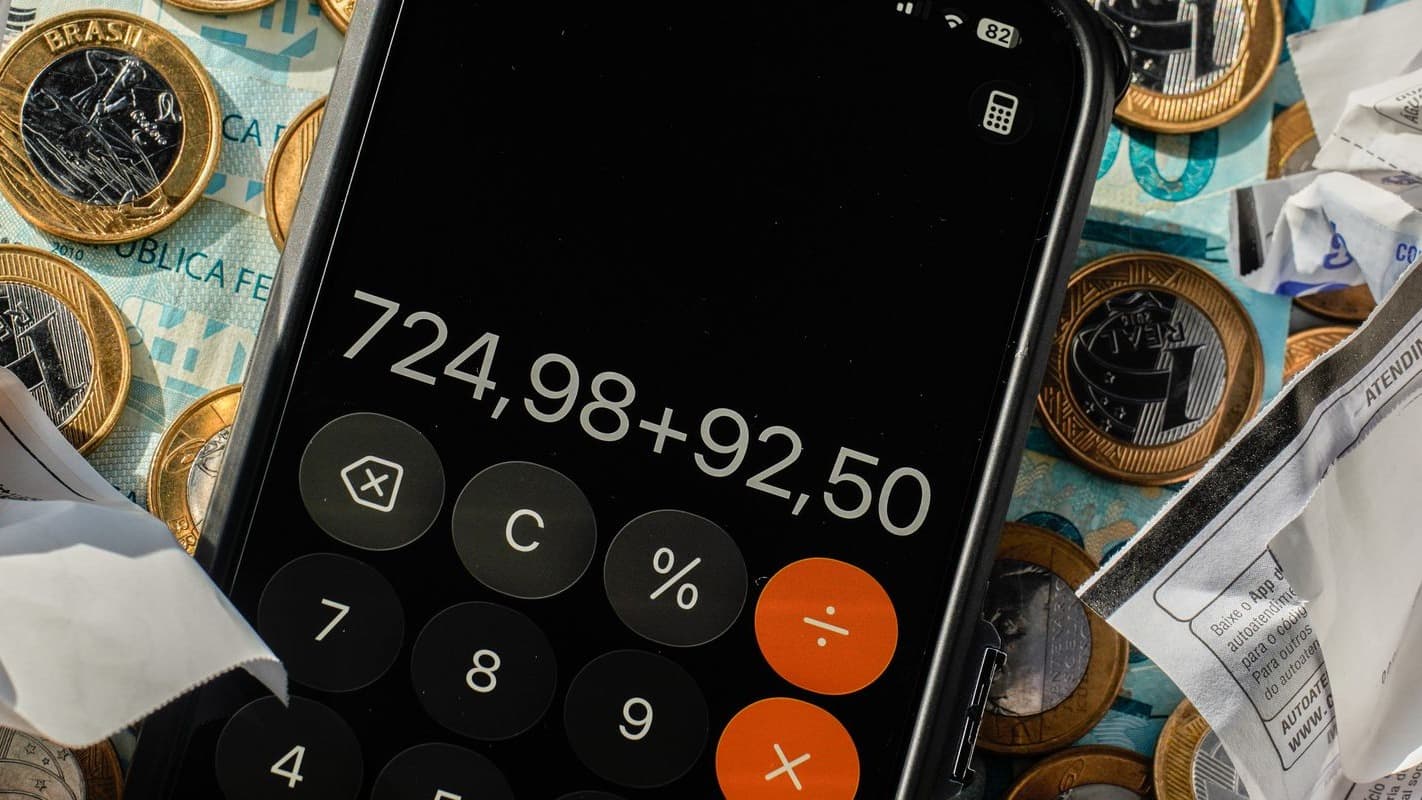 Calculadora no celular sobre dinheiro em espécie e recibos