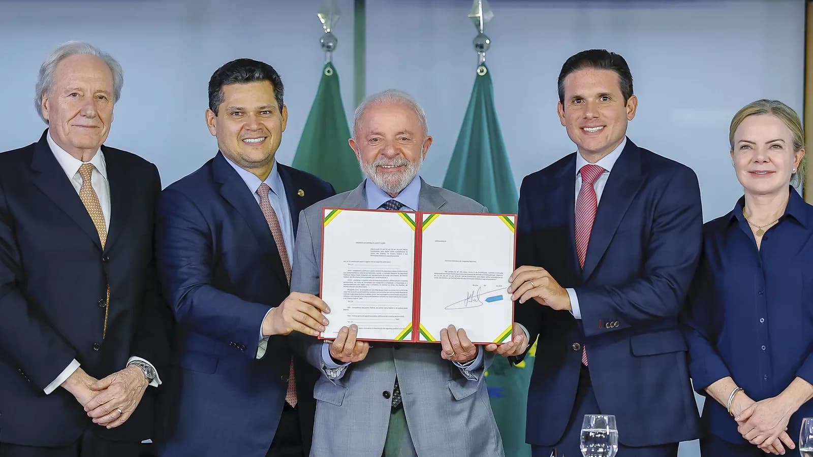 O presidente Lula ao lado de autoridades segurando o documento da PEC da Segurança Pública em cerimônia no Palácio do Planalto
