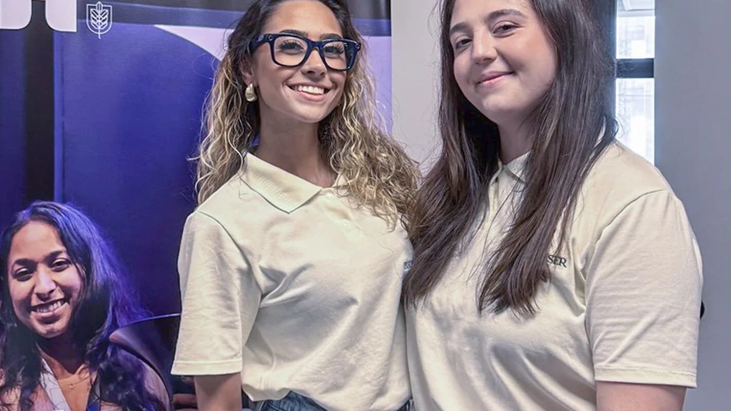 Duas jovens pesquisadoras sorridentes em ambiente universitário (foto ilustrativa)