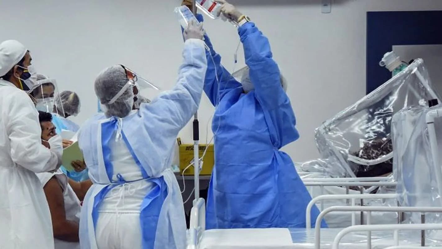 Profissionais de enfermagem paramentados atendem paciente em leito hospitalar (foto de arquivo, ilustrativa)