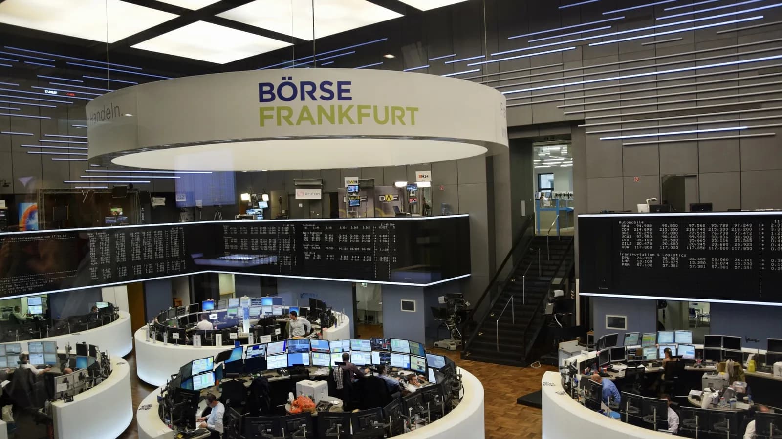 Sala de operações da Bolsa de Frankfurt, com telas de cotação e operadores trabalhando sob o letreiro Börse Frankfurt