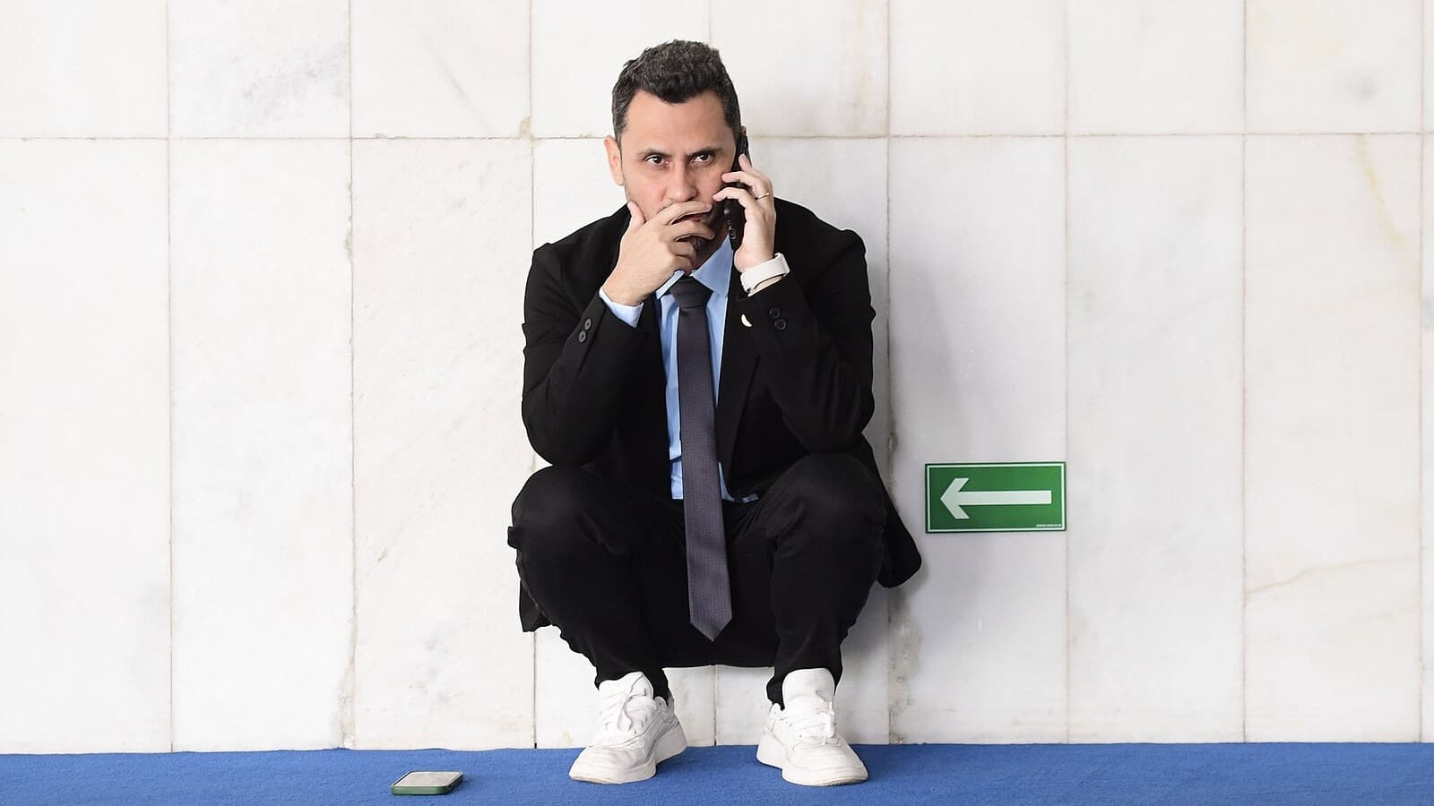 Senador Cleitinho Azevedo, candidato ao governo de Minas Gerais, agachado ao telefone em corredor do Senado Federal, em foto de arquivo de abril de 2025.