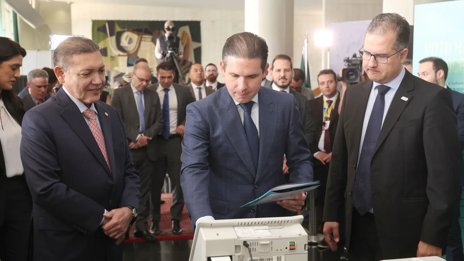Autoridades observam urna eletrônica durante exposição sobre o voto no Brasil