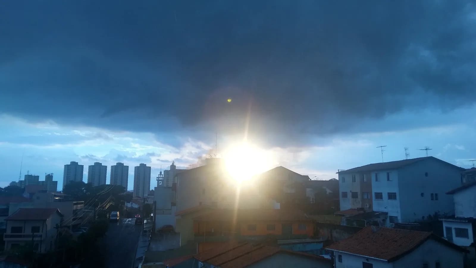 Vista aérea de Taboão da Serra ao entardecer, com casas e prédios sob céu parcialmente nublado