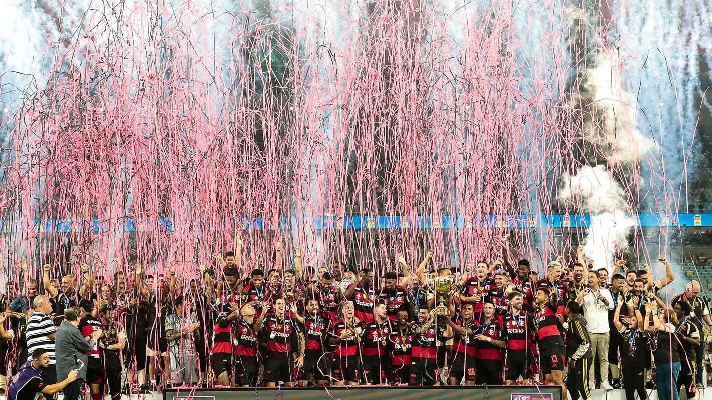 Jogadores do Flamengo celebram título com fogos de artifício e confete no gramado, foto de arquivo de comemoração do clube