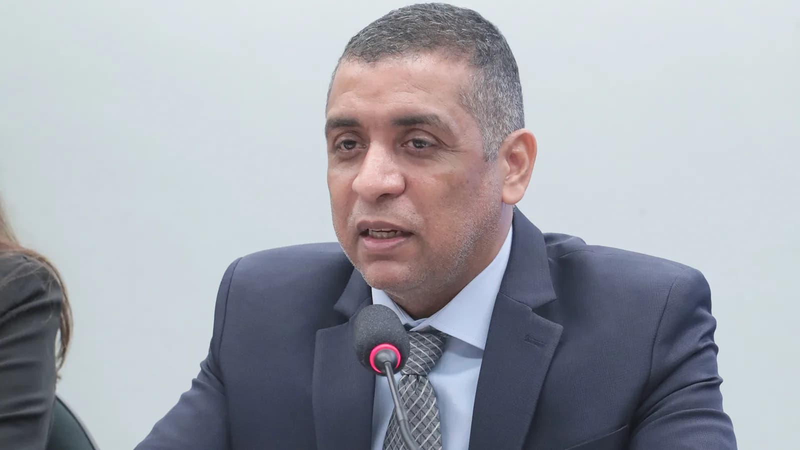 Representante de sindicato de bancários fala ao microfone em audiência pública na Câmara dos Deputados