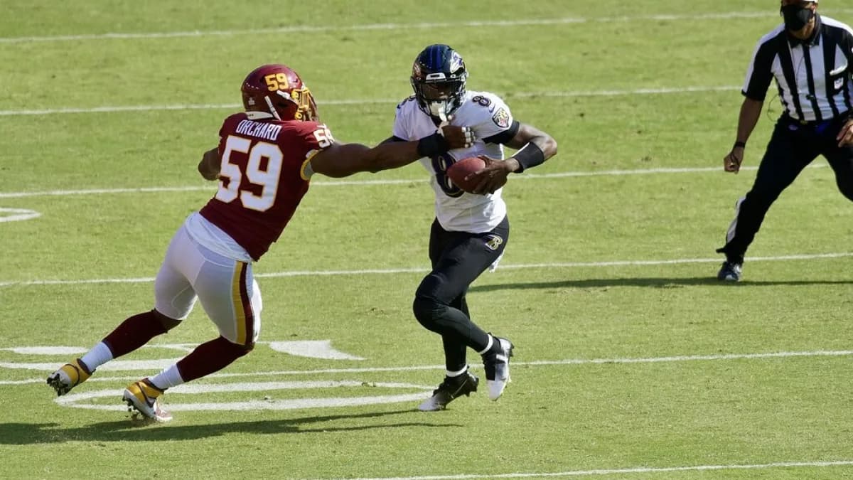 Lamar Jackson, quarterback do Baltimore Ravens, corre com a bola durante jogo da NFL
