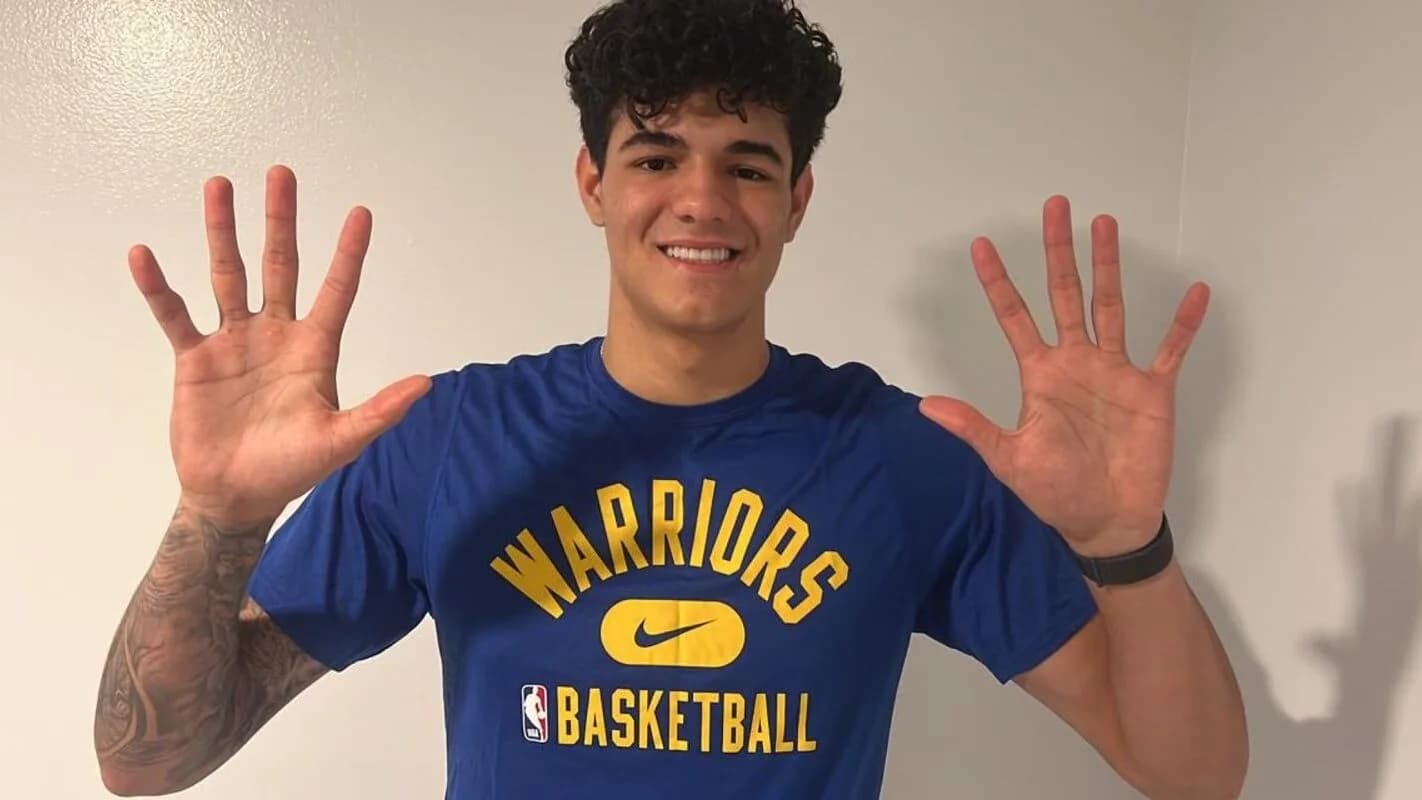 Gui Santos sorri com as mãos abertas vestindo camisa do Golden State Warriors, em foto de arquivo de 2022
