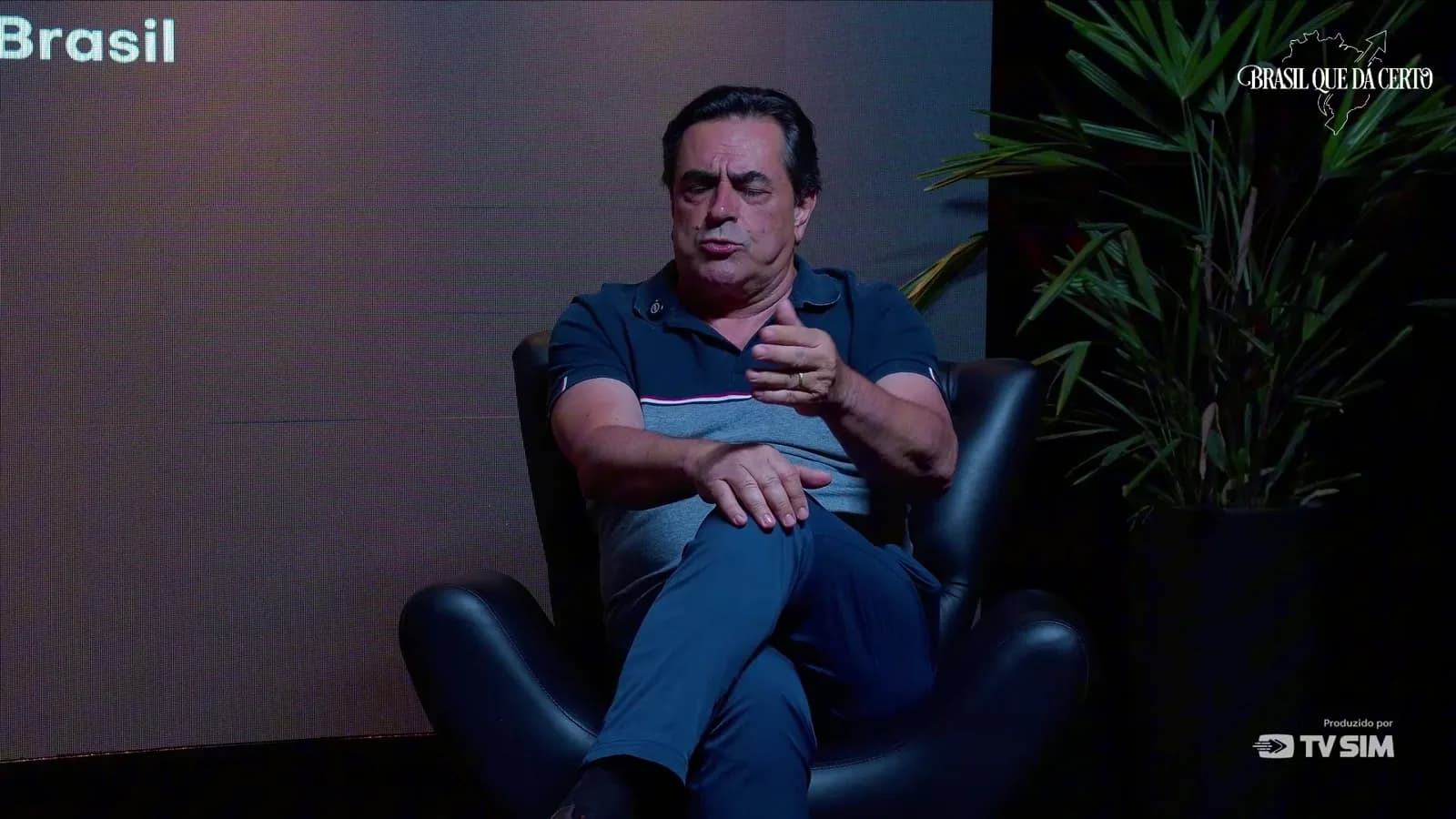 Domingos Sávio, sentado em poltrona preta, gesticula com a mão direita durante entrevista ao programa Brasil que Dá Certo.