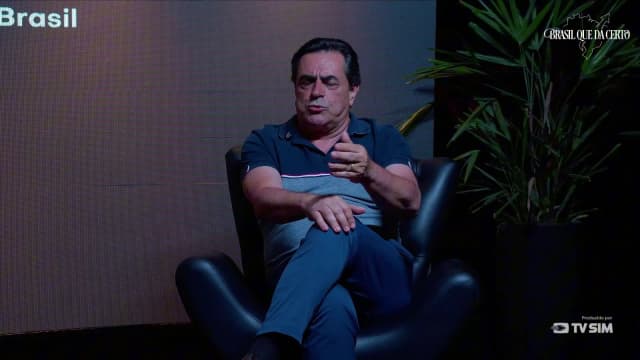 Domingos Sávio, sentado em poltrona preta, gesticula com a mão direita durante entrevista ao programa Brasil que Dá Certo.