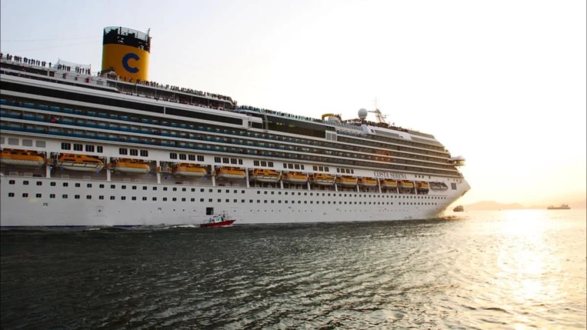 Navio de cruzeiro Costa Serena ao entardecer no porto de Santos, com passageiros no convés
