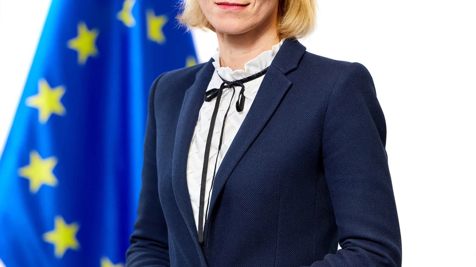 Retrato oficial de Kaja Kallas, Alta Representante da União Europeia para Negócios Estrangeiros, com a bandeira da UE ao fundo