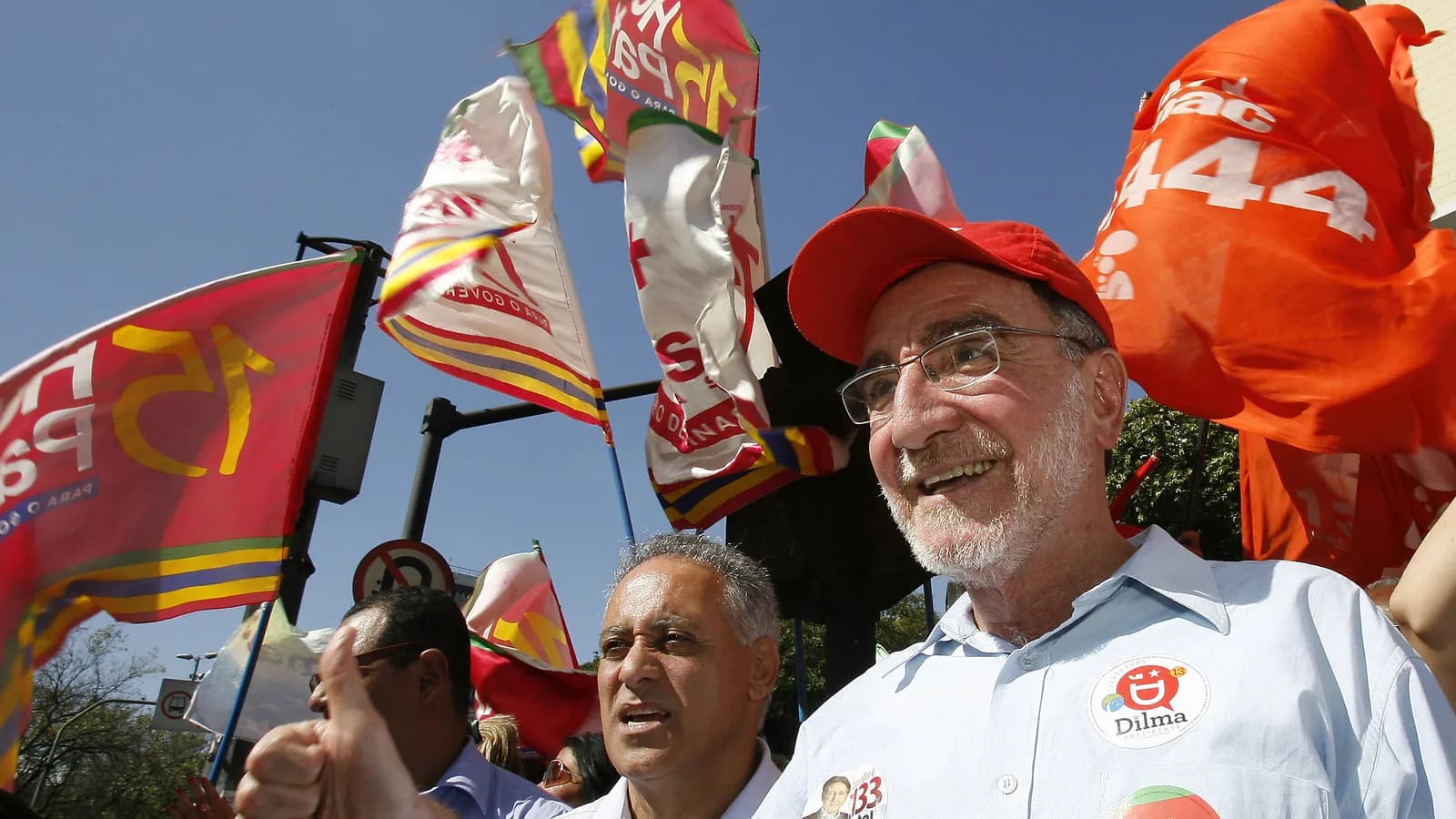 Patrus Ananias sorri em ato de campanha, cercado de bandeiras do PT, em foto de arquivo de 2010