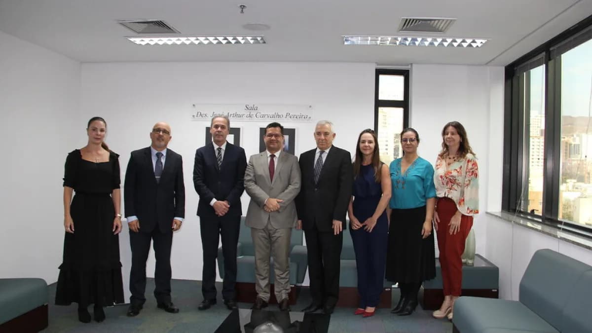 Grupo de autoridades do TRE-MG posa em sala de reunião durante assinatura de acordo de cooperação