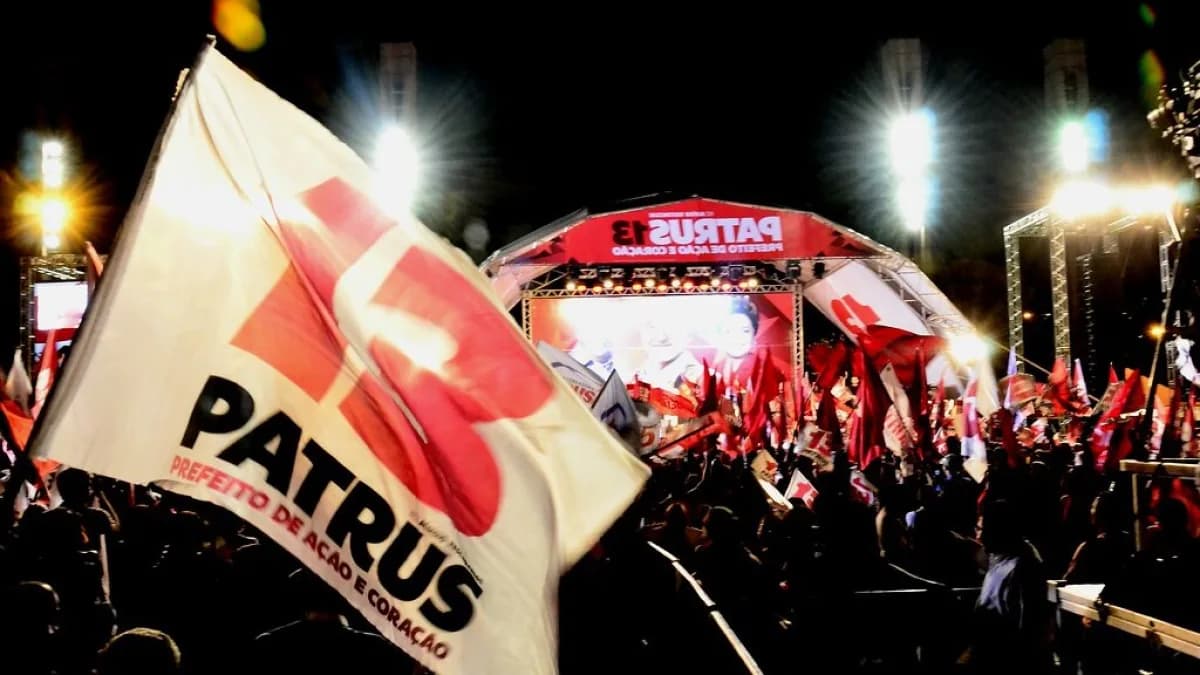 Apoiadores seguram bandeira de Patrus Ananias em ato de campanha em Belo Horizonte