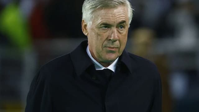 Técnico Carlo Ancelotti observa o jogo em campo, com expressão séria