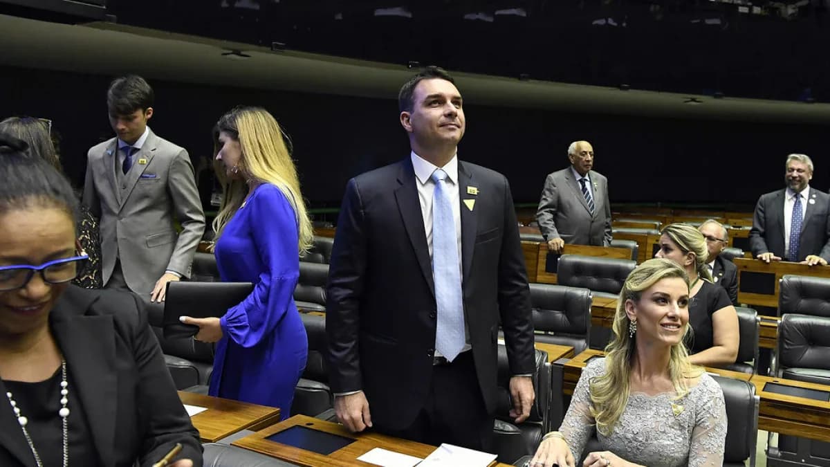 O senador Flávio Bolsonaro em pé no plenário do Congresso Nacional, de terno escuro e gravata azul