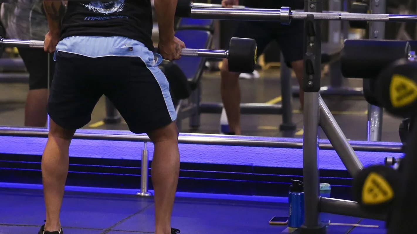 Pessoa treina com barra em academia; suplementos proteicos são comuns entre praticantes (foto de arquivo)