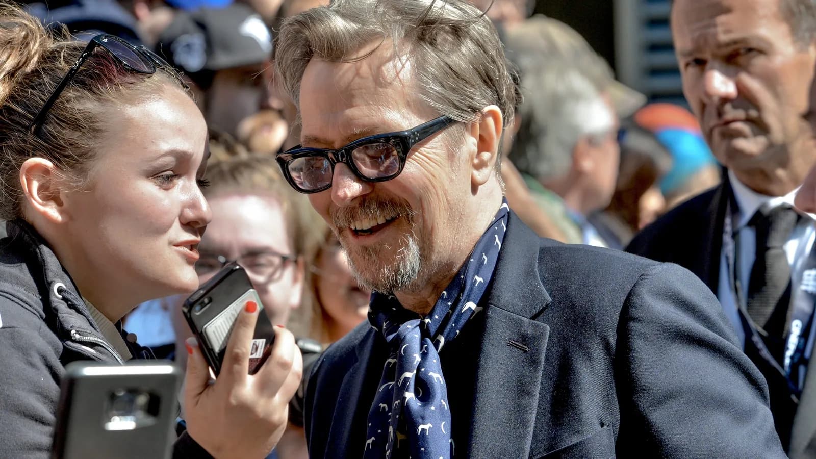 Gary Oldman sorri para fãs durante evento em tapete vermelho