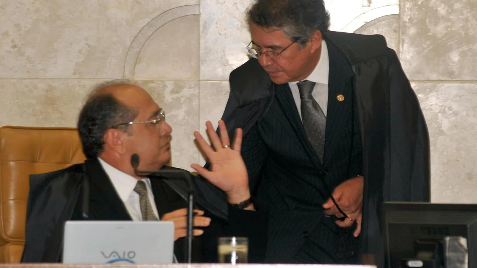 Ministro Gilmar Mendes gesticula ao lado de outro ministro durante sessão de julgamento no STF