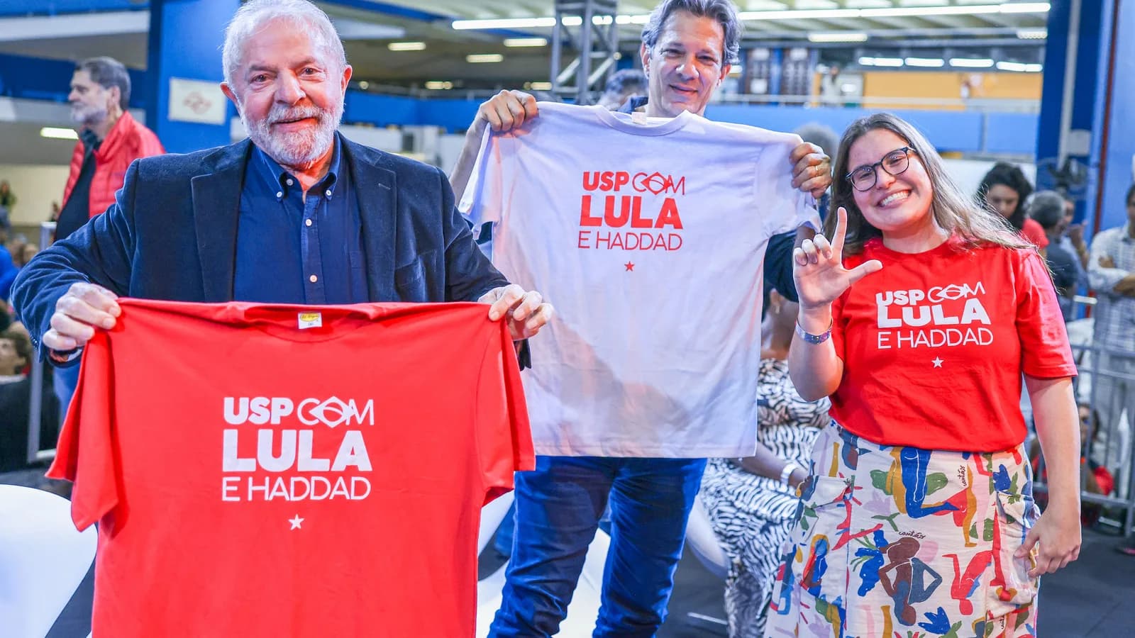 Lula e Fernando Haddad seguram camiseta de campanha ao lado de estudante na USP, em foto de arquivo de 2022