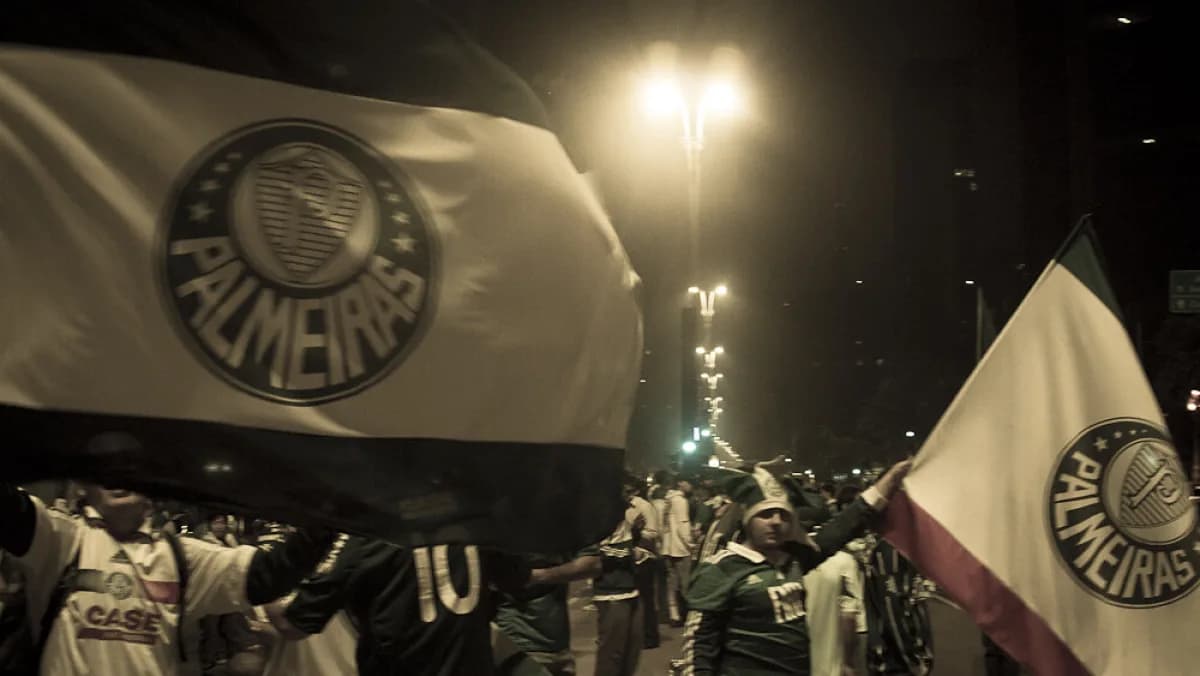 Torcedores do Palmeiras com bandeiras do time durante comemoração à noite