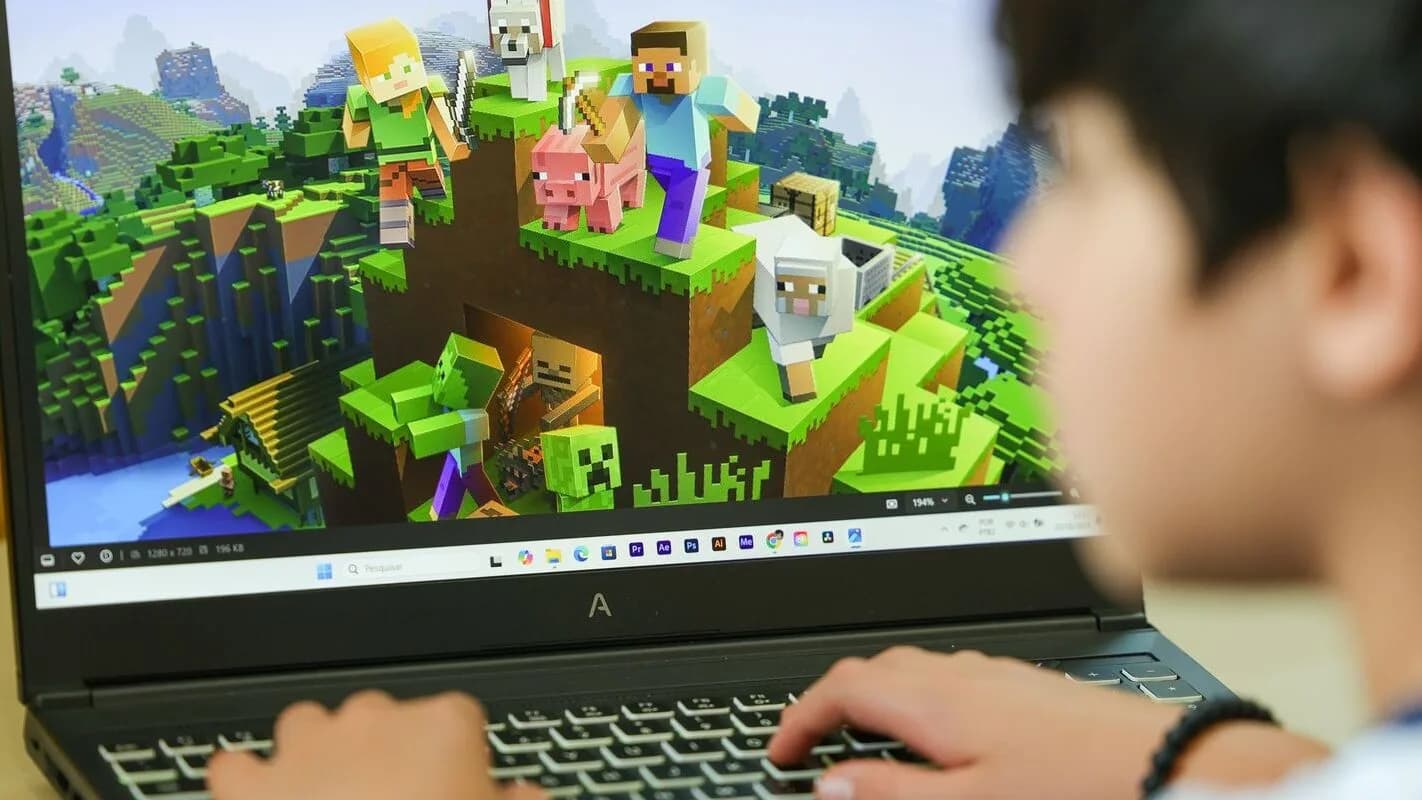 Jovem usa computador portátil em cena sobre uso de telas e dispositivos digitais