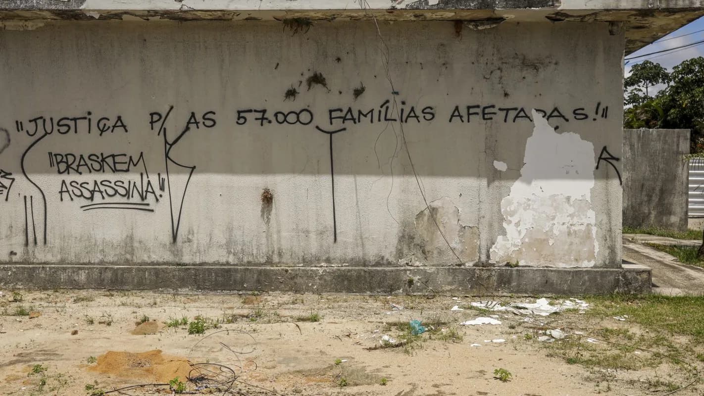 Grafite em muro de prédio abandonado cobra justiça para famílias afetadas e critica a Braskem, em área do afundamento do solo em Maceió (AL)