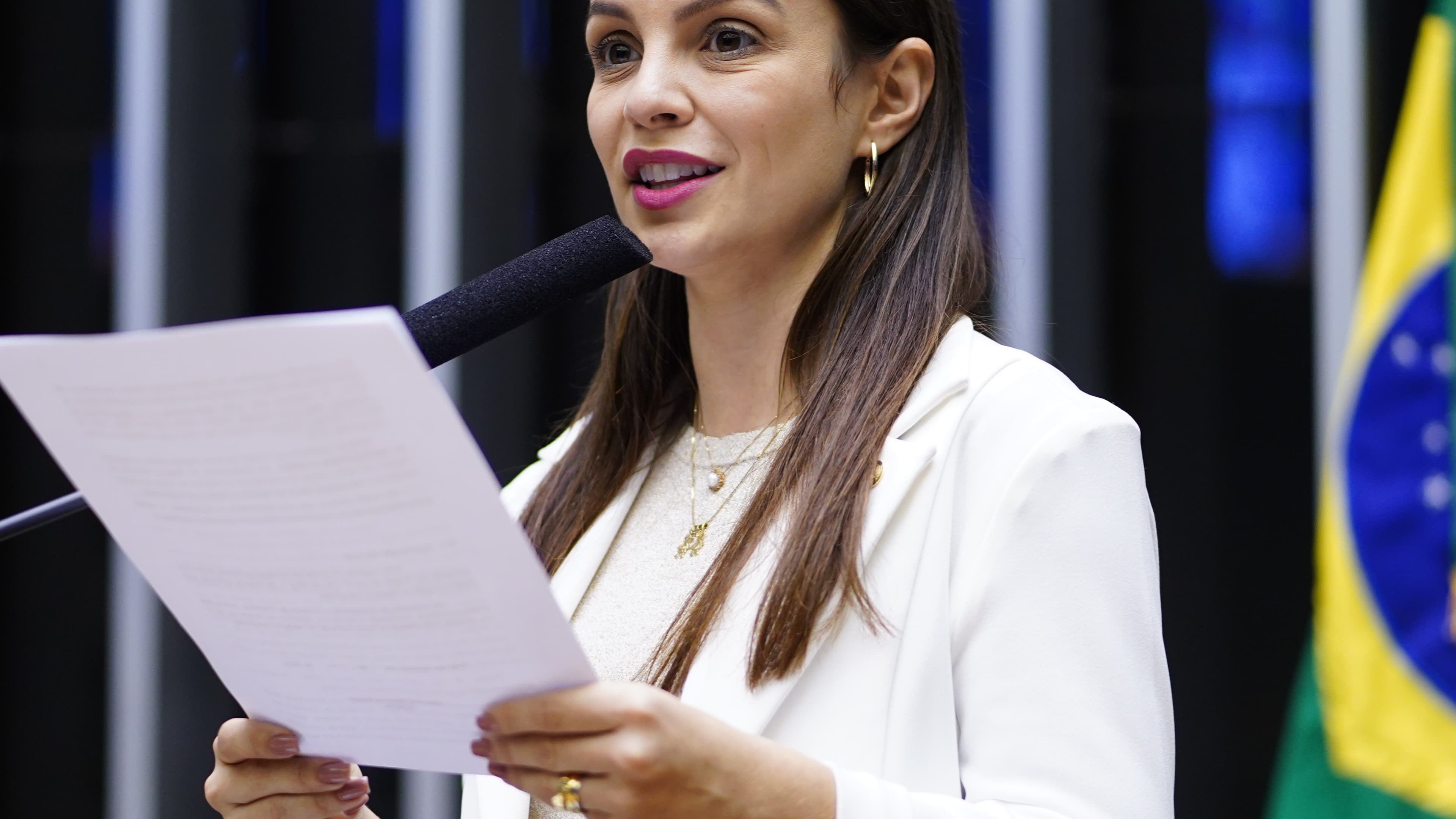 Deputada Marussa Boldrin discursa no plenário da Câmara dos Deputados, com a bandeira do Brasil ao fundo