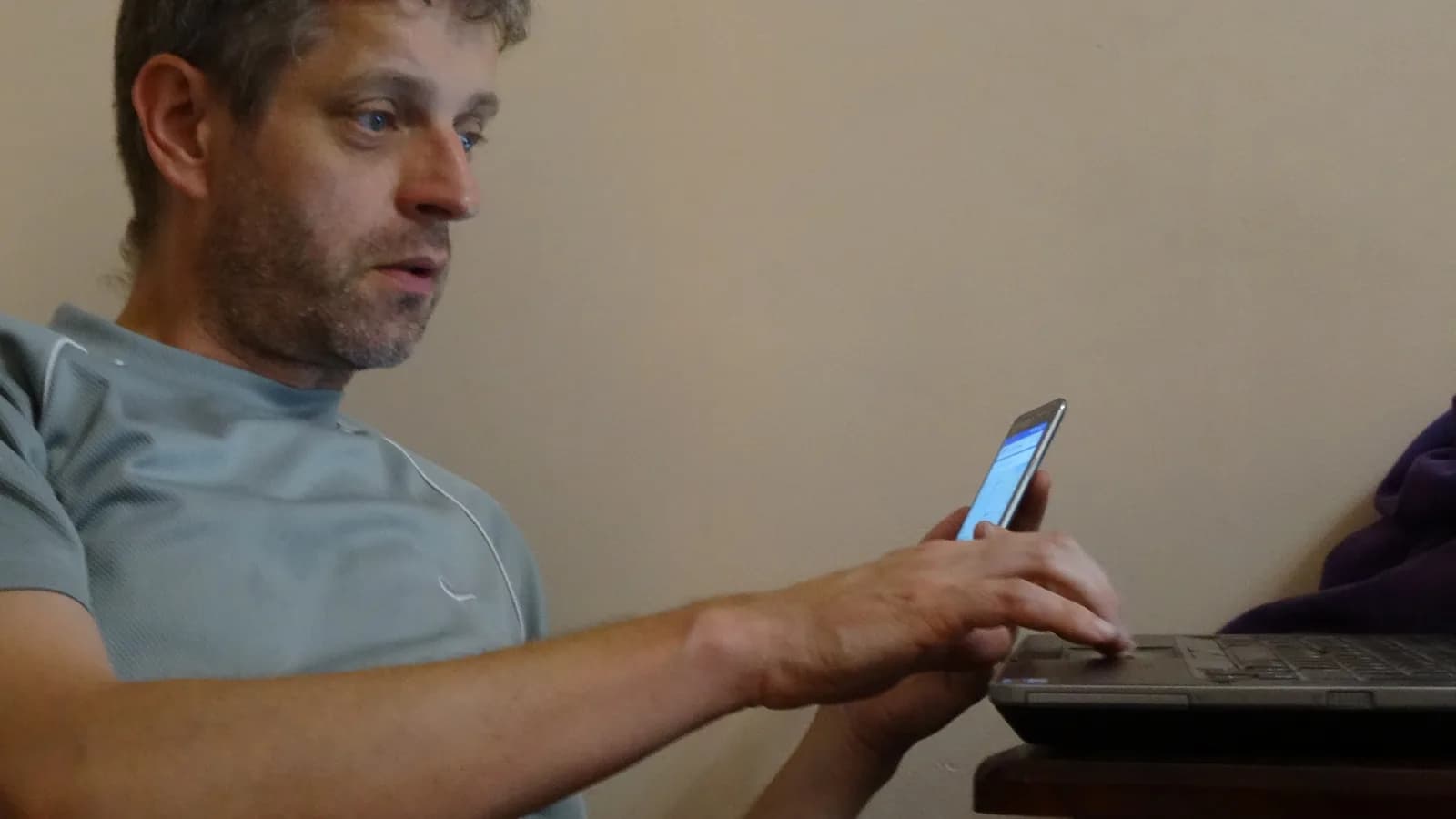 Homem usa celular e notebook em foto de arquivo ilustrativa sobre busca na internet