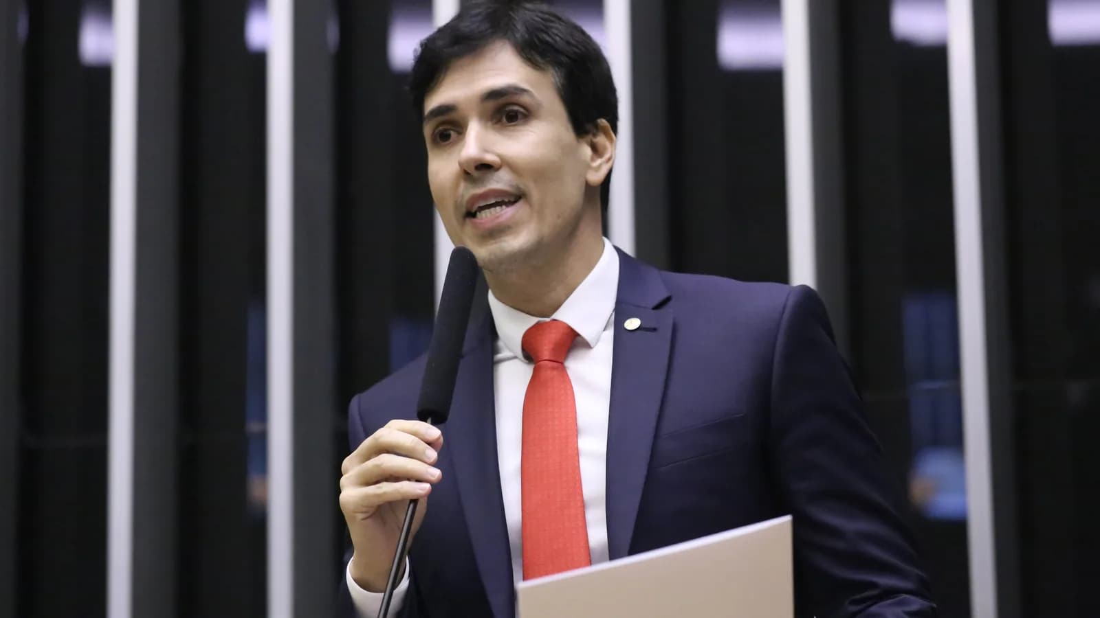 Euclydes Pettersen discursa em plenário da Câmara dos Deputados, de terno escuro e gravata vermelha