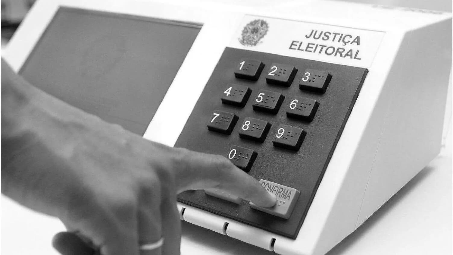 Dedo pressiona teclado de urna eletrônica da Justiça Eleitoral