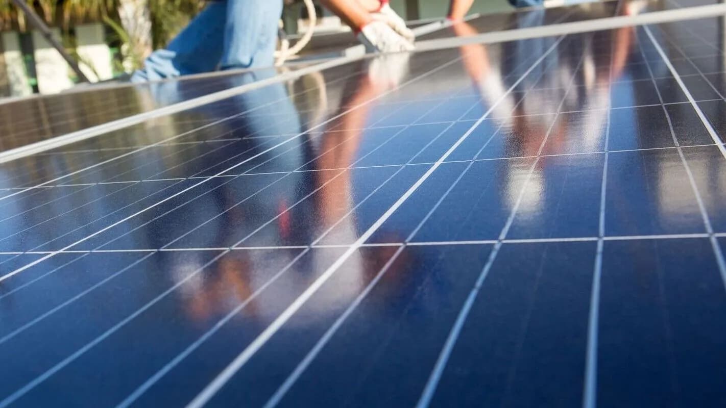 Pessoas instalam placas de energia solar fotovoltaica em projeto de energia renovável no Brasil