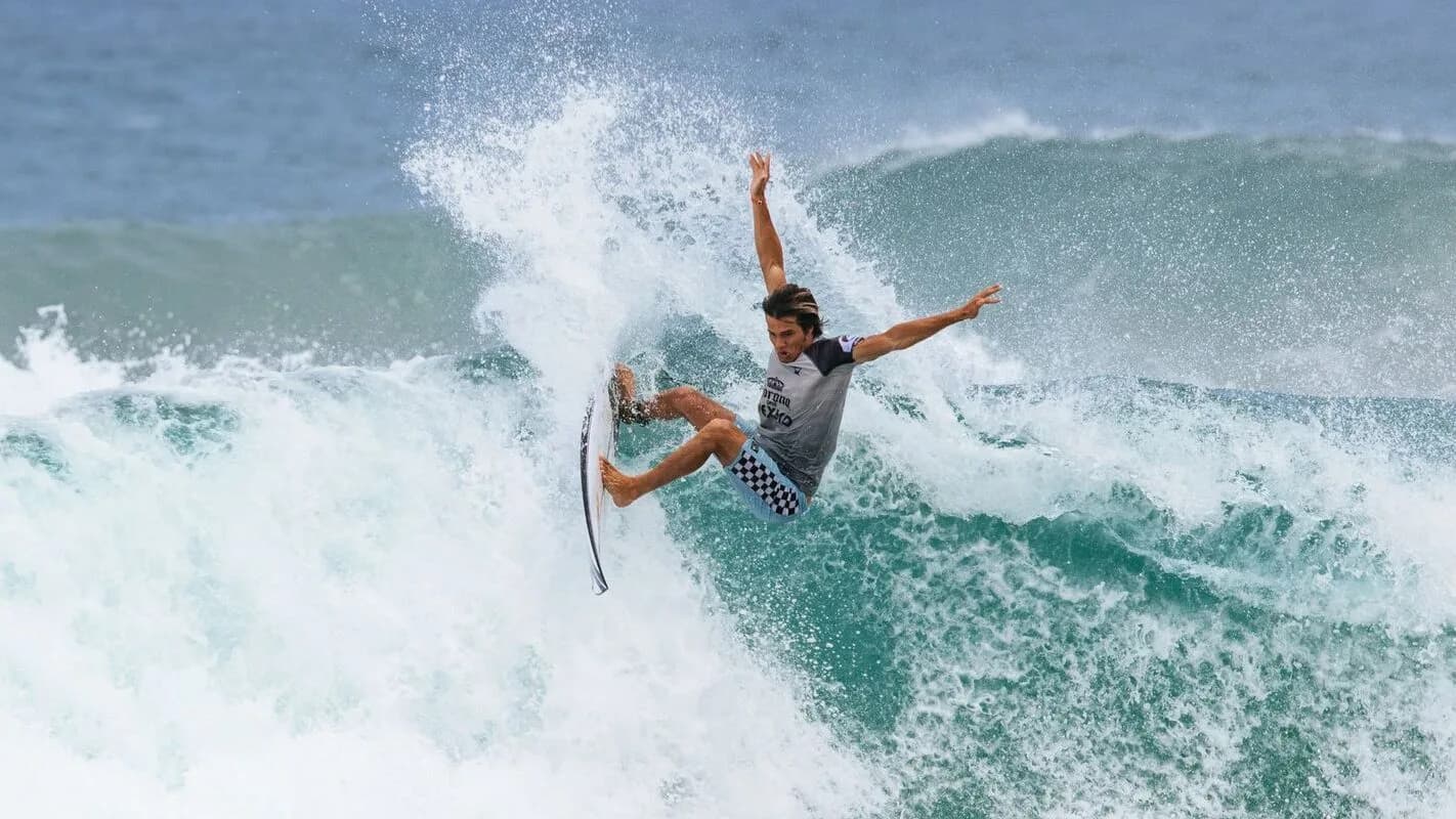 Surfista faz manobra aérea sobre onda, foto de arquivo
