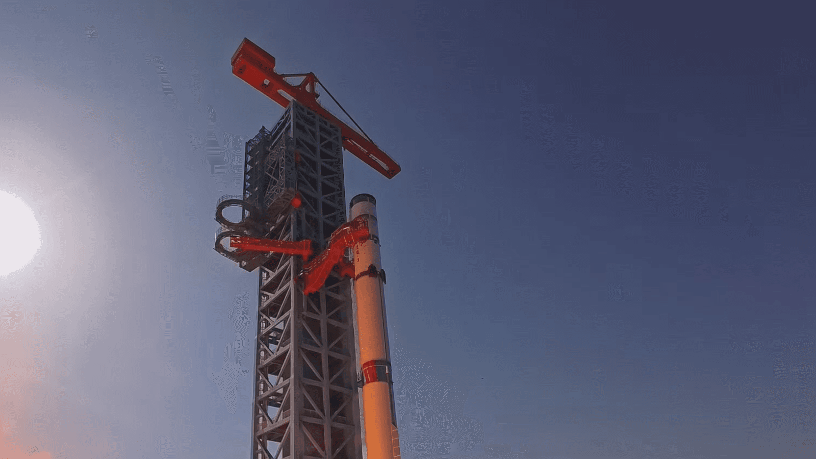 Foguete Zhuque-3 na plataforma de lançamento durante teste com labaredas visíveis na base
