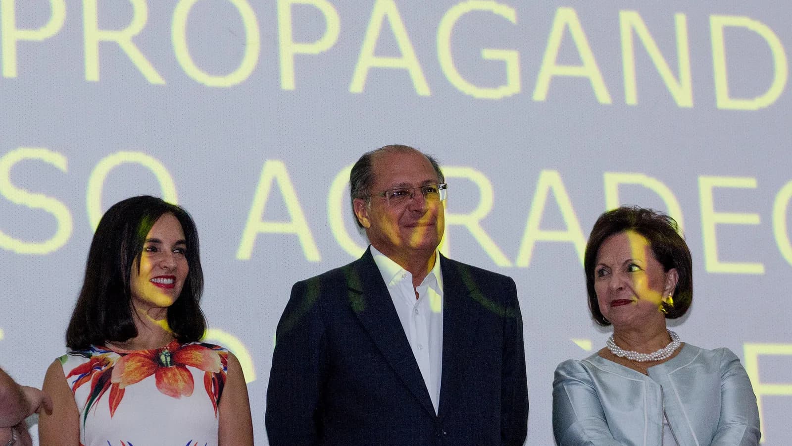 Geraldo Alckmin em evento de campanha com painel de propaganda eleitoral ao fundo