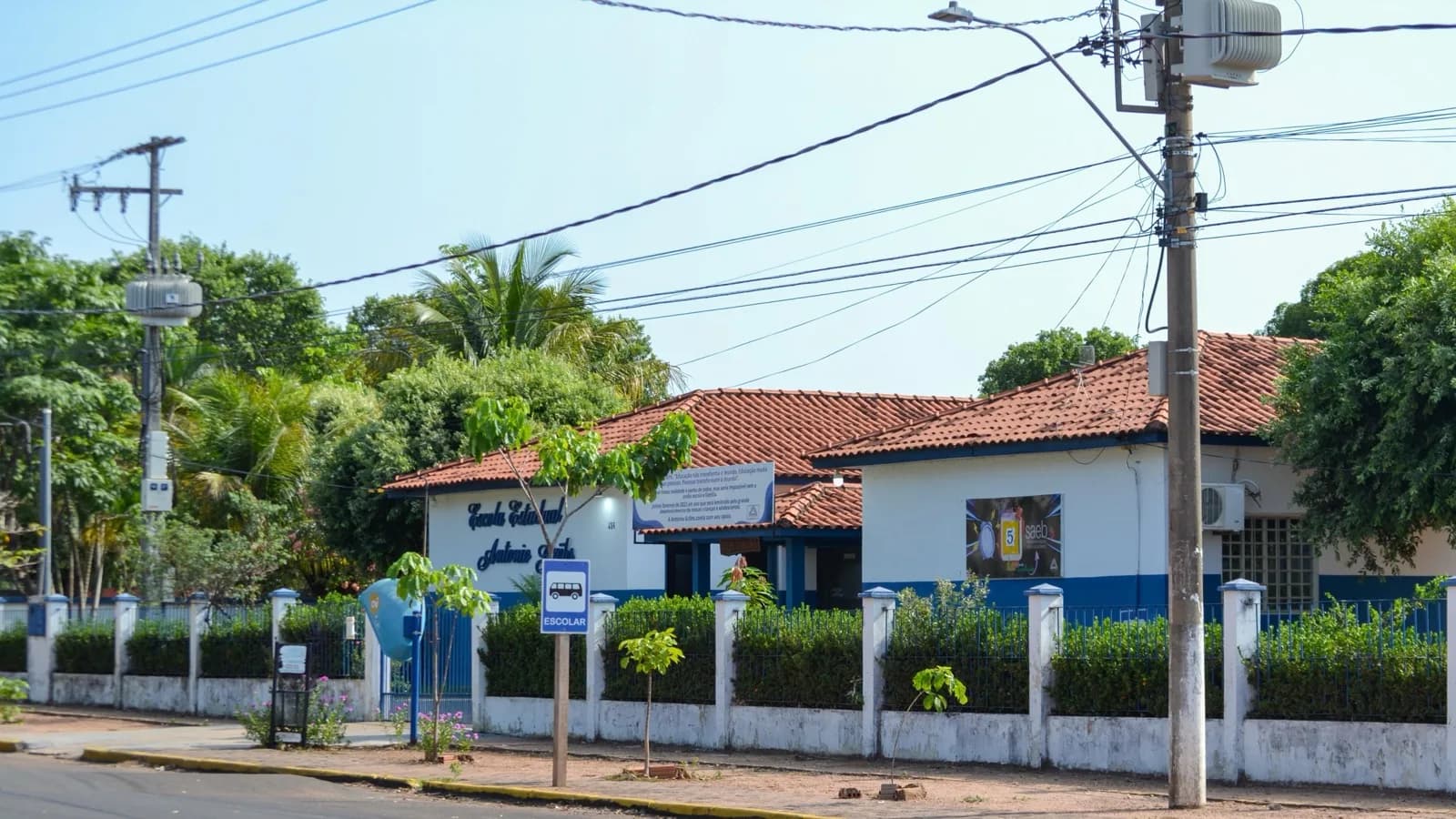 Fachada de escola estadual, com portão, muro e placa de ponto escolar (foto ilustrativa)