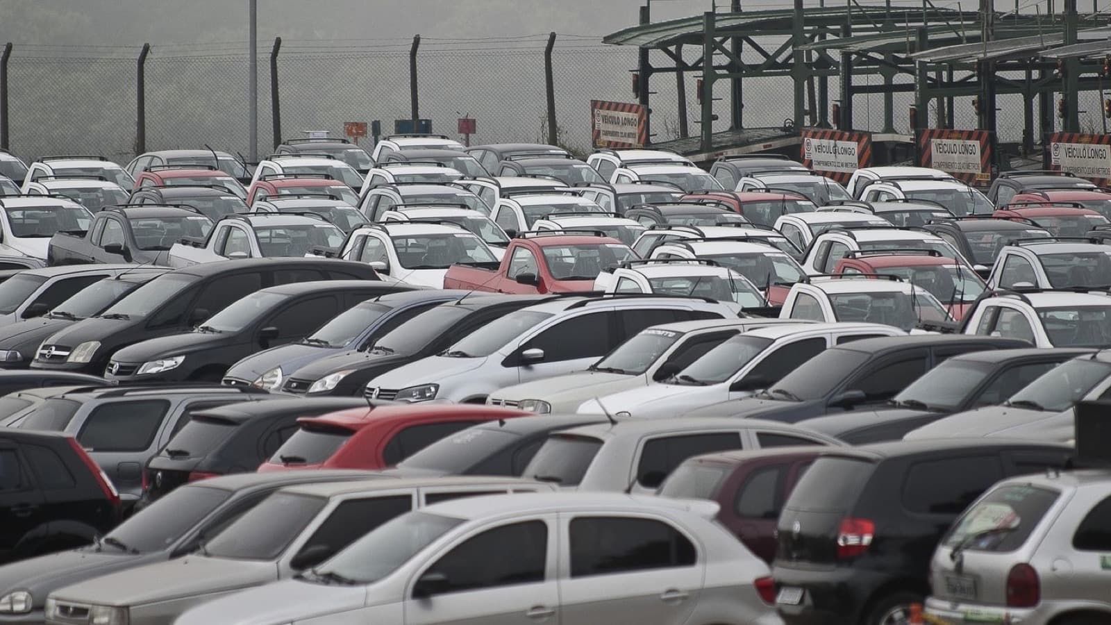 Pátio com centenas de carros novos estacionados lado a lado, aguardando distribuição a concessionárias (imagem de arquivo de montadora, sem relação com marca específica citada na matéria)