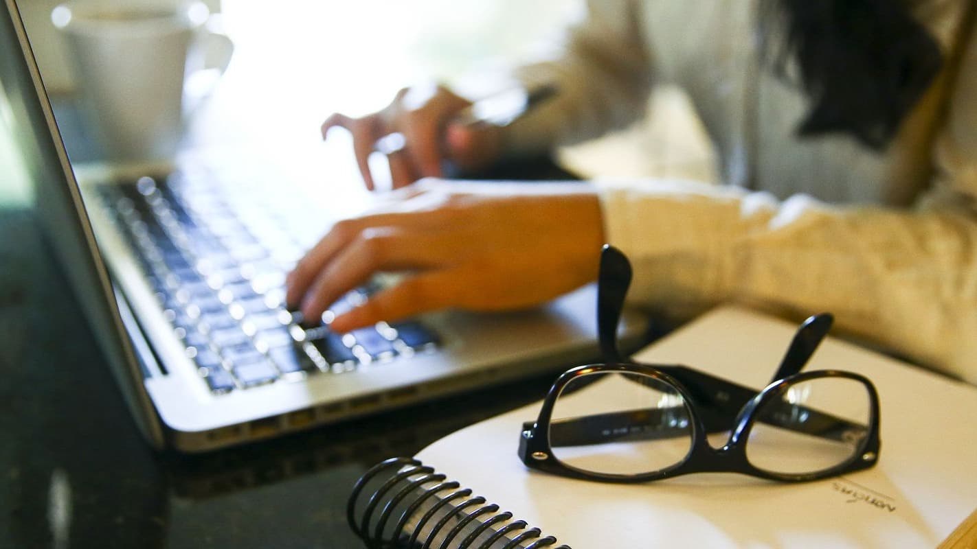 Mulher digita em notebook em imagem ilustrativa sobre trabalho no setor de seguros