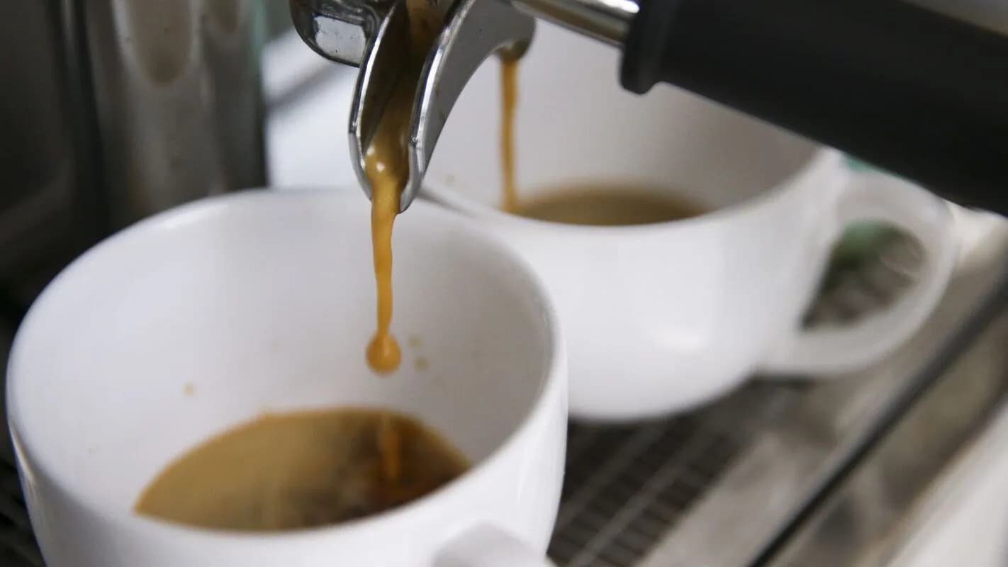 Café especial sendo preparado em cafeteria, com xícaras em primeiro plano