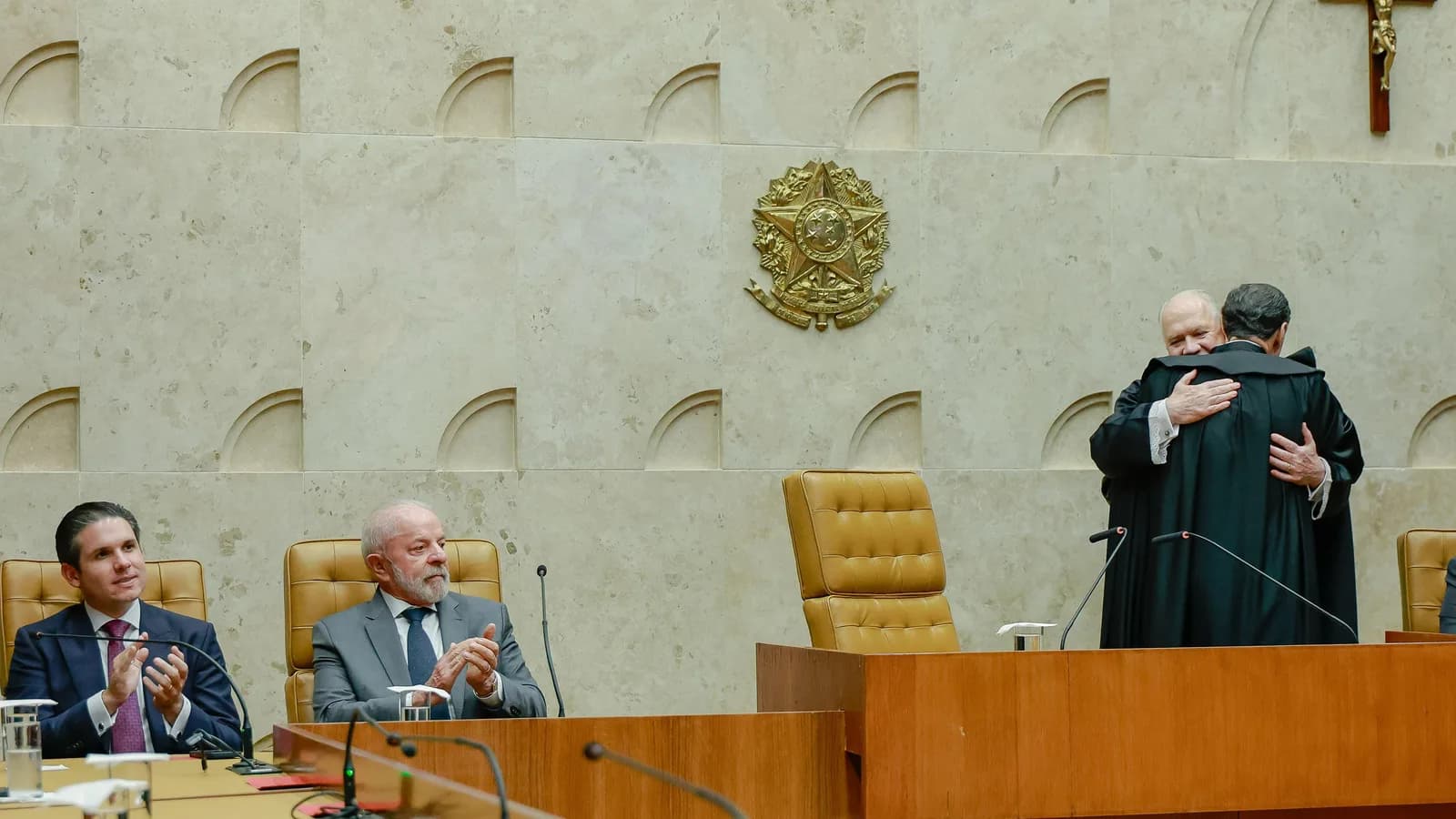 Ministros se cumprimentam no plenário do Supremo Tribunal Federal, com o presidente Lula ao fundo
