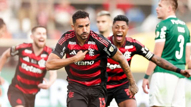 Jogador do Flamengo comemora gol durante partida, com colegas ao fundo